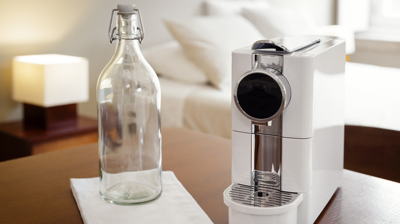 coffee pod machine and water bottle on table