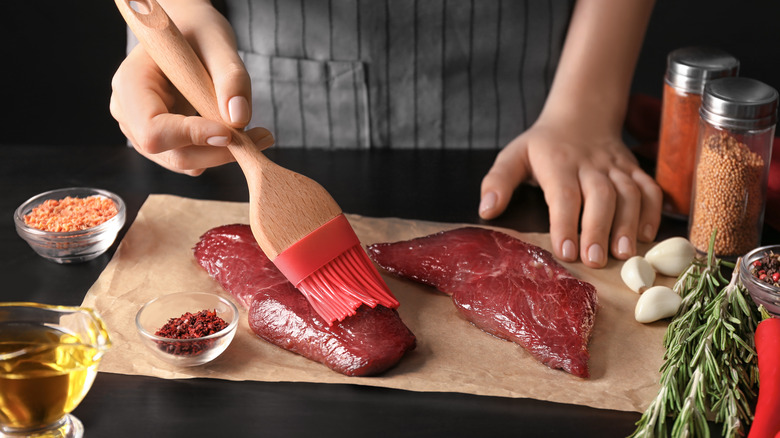 Brushing the steak with oil