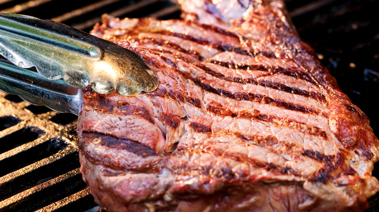 Flipping the steak on a BBQ