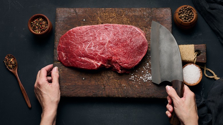 Trimmed steak with hands and knife