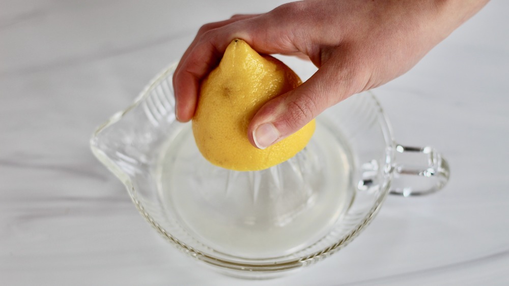 Glass citrus juicer with a lemon over top