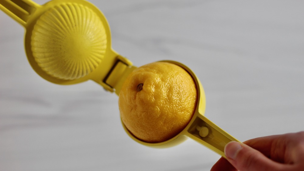 Yellow lemon squeezer with lemon inside