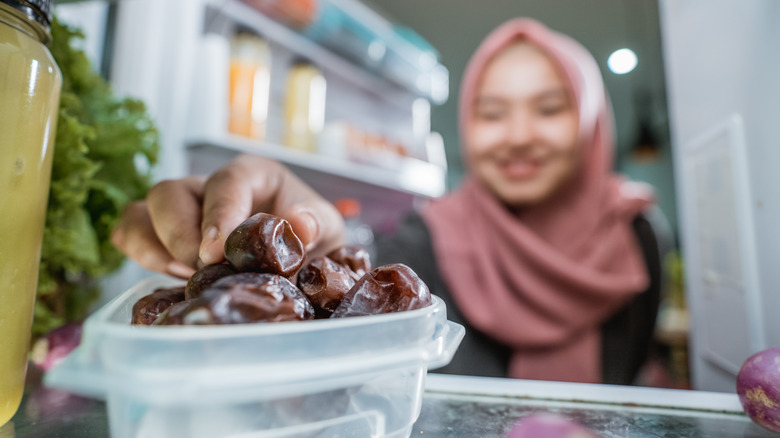 Woman grabbing dates from the refrigerator