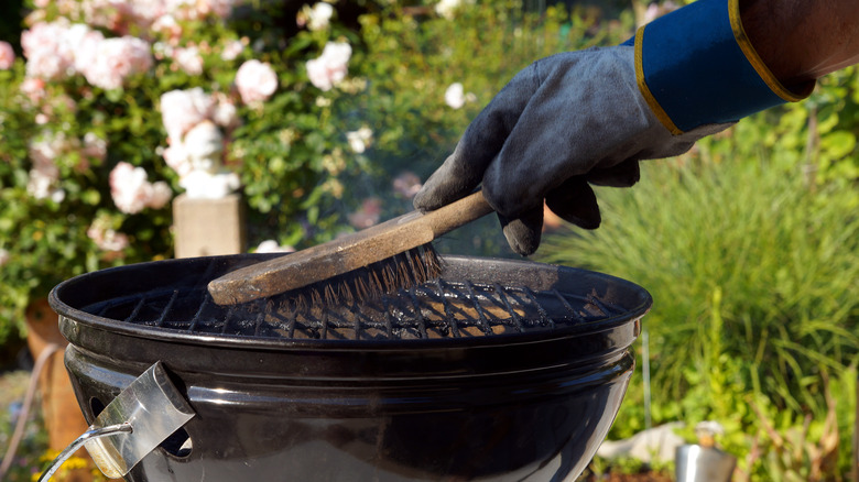 Gloved hand cleaning grill grates