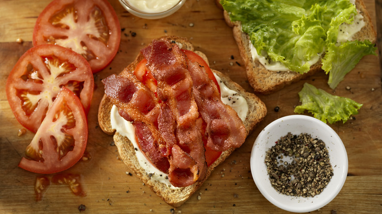 Disassembled BLT and ingredients on a wooden cutting board