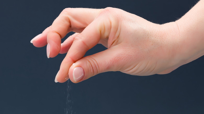 Closeup of hand with a pinch of salt