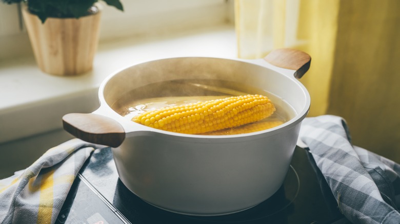 soaking corn in hot water in a pot