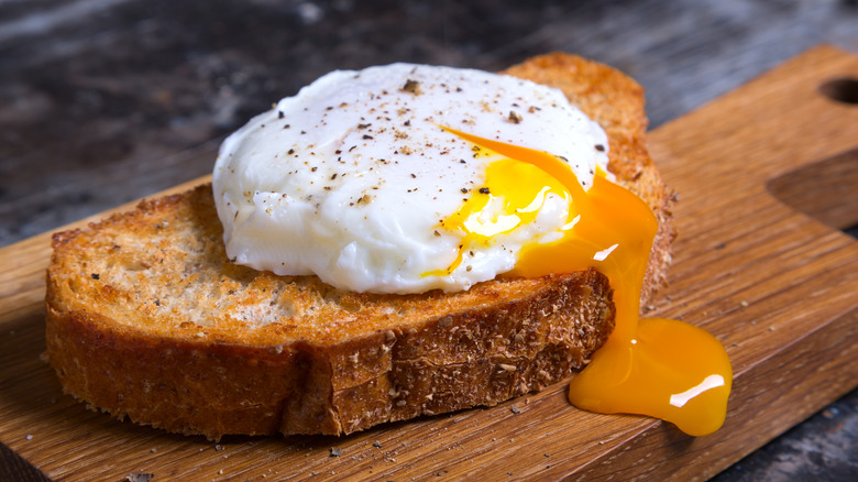 Poached egg on toast with yolk pouring out