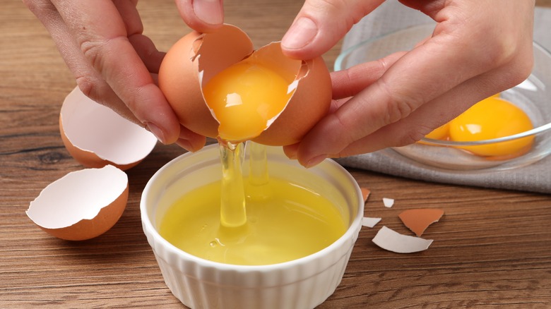 Person separating egg whites from yolks