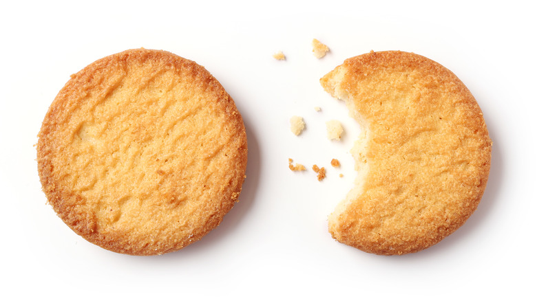 Two shortbread cookies with bite out of one