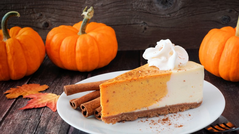 Pumpkin cheesecake next to cinnamon sticks