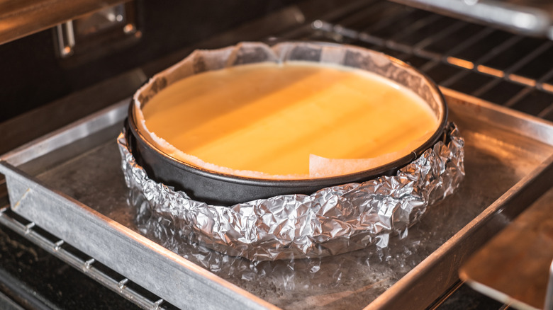 Cheesecake pan wrapped in foil in bain marie