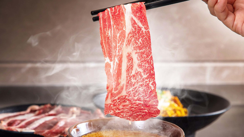 Thin slice of Wagyu held over hot pot