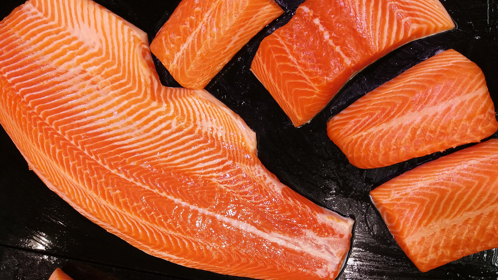 Different cuts of salmon on black background