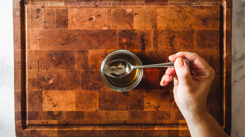 lifting a spoon of apple cider vinegar