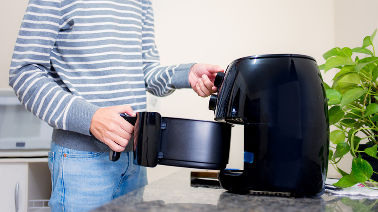 person using air fryer