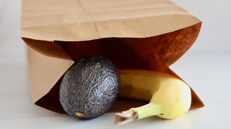 Avocado and banana placed in brown paper bag