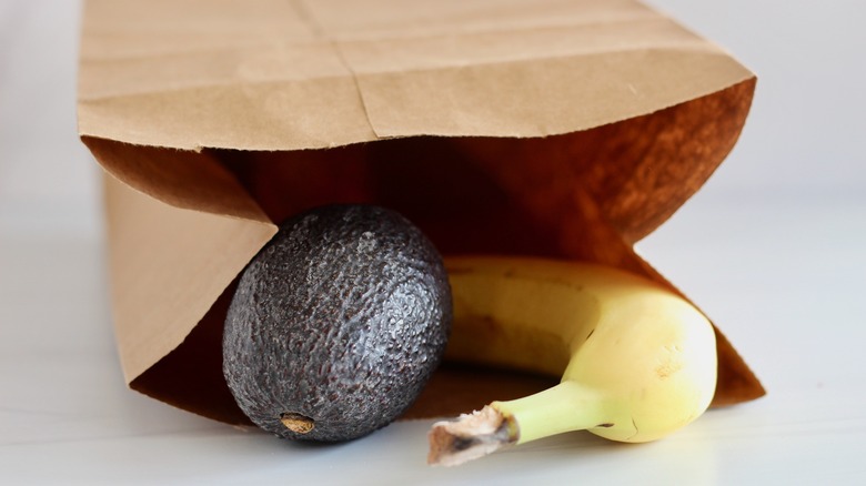 Avocado and banana placed in brown paper bag