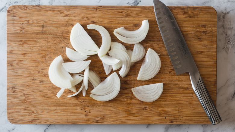 sliced onions and knife on cutting board