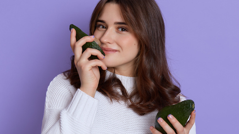 person smelling avocado