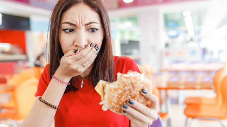 woman with bad taste after eating hamburger