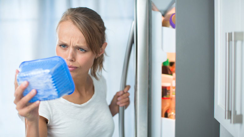 Woman checking expiration date on container