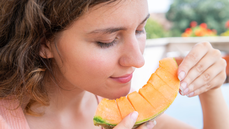 Person smelling cut cantaloupe