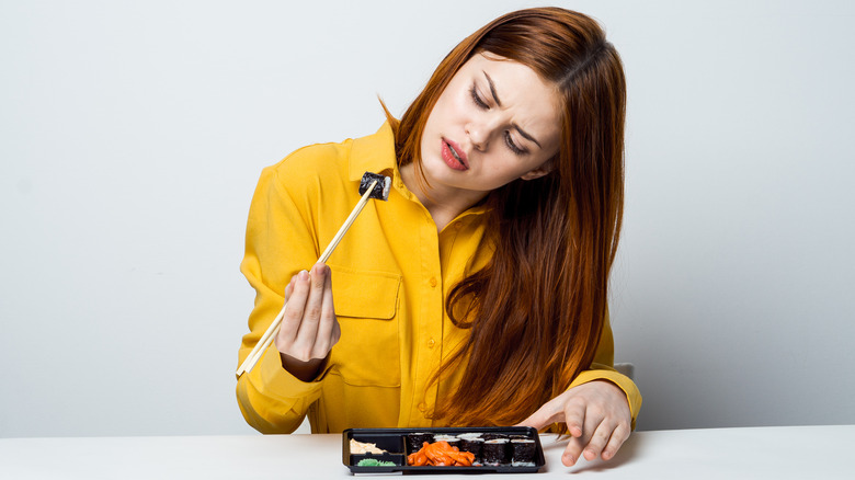Woman looking skeptical at sushi