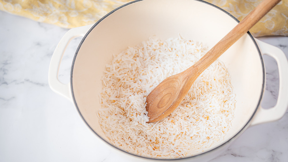 stirring coconut in a pot