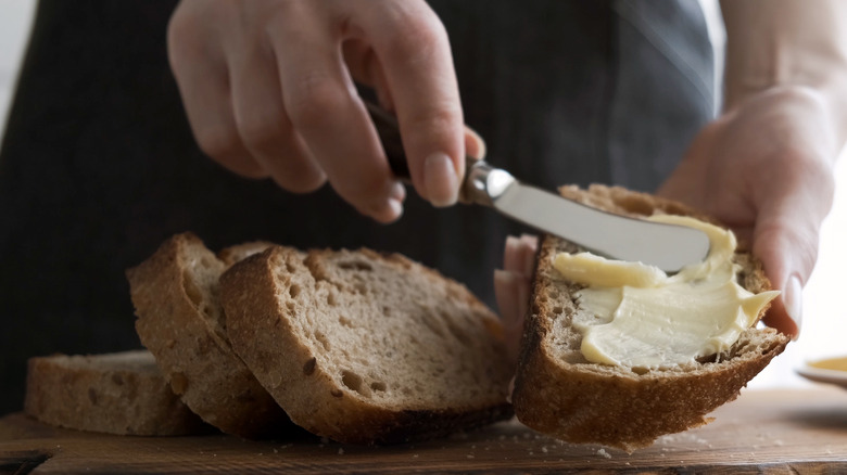 person spreading butter