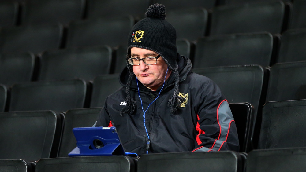 Man views tablet in stadium