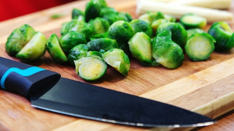 Brussels sprouts and knife on cutting board
