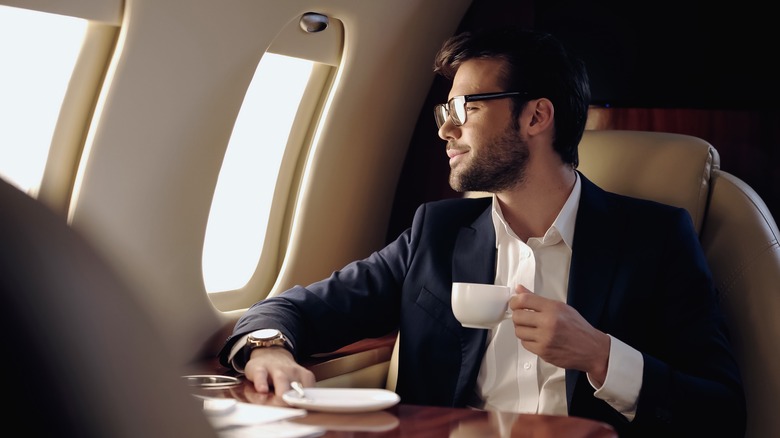 Man enjoys coffee on an airplane