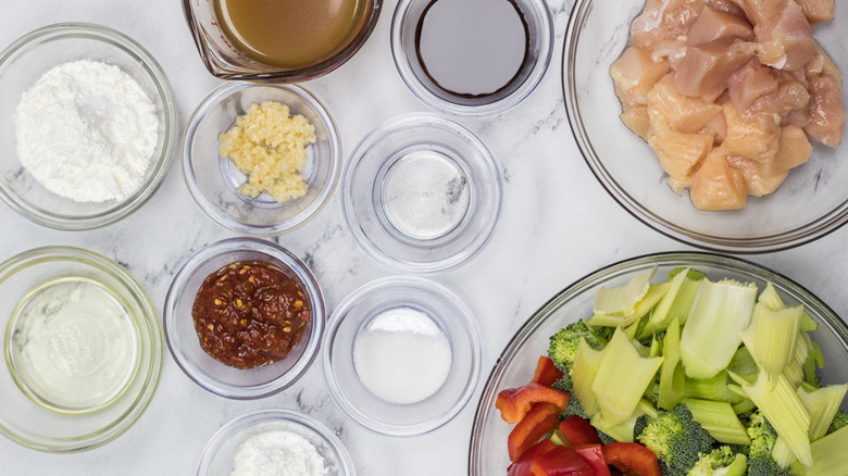 Sauce ingredients and bowls of vegetables and chicken for Hunan chicken