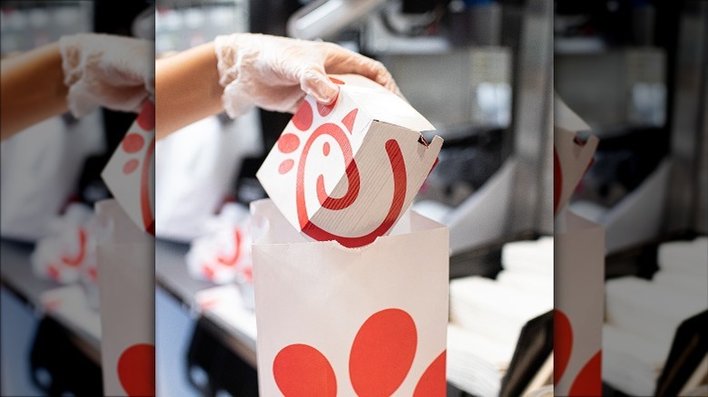 putting Chick-fil-A sandwich in bag