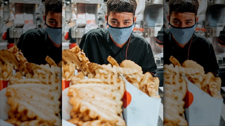 worker and waffle fries in Chick-fil-A kitchen