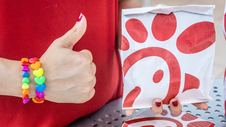 giving thumbs up to chick-fil-a sandwich bag