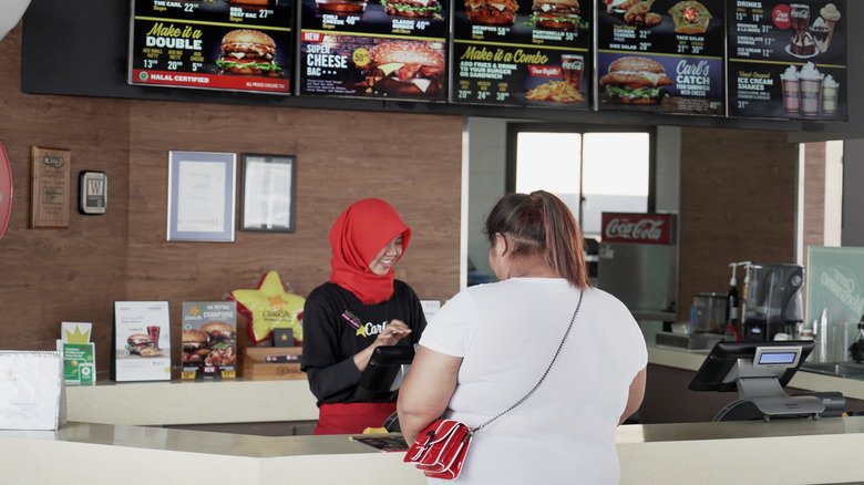 Employee taking a customer's order at Carl's Jr.