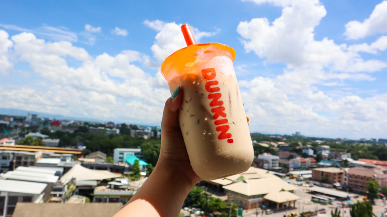 Hand holds an iced coffee 