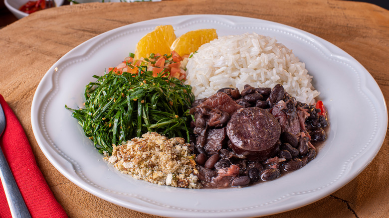 Plate of feijoada with traditional accompaniments