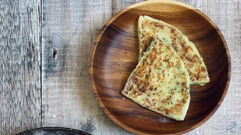 two potato farls on wooden plate and wooden background