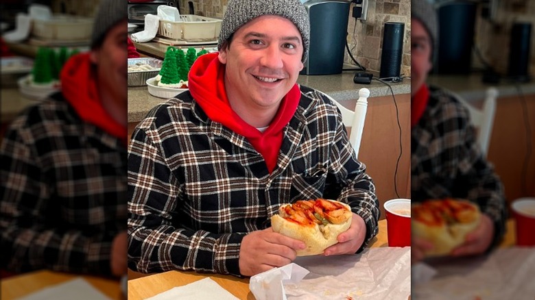 man holding Italian hot dog