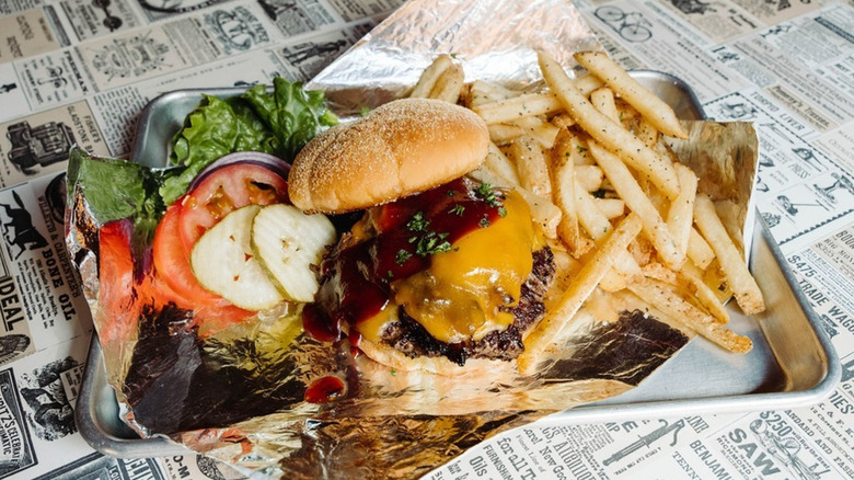 Barbecue cheeseburger with lettuce, tomato, onion and a side of fries