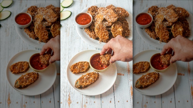 hand touching fried zucchini piece