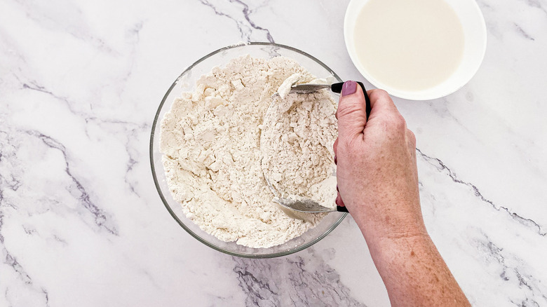 hand cutting butter into flour