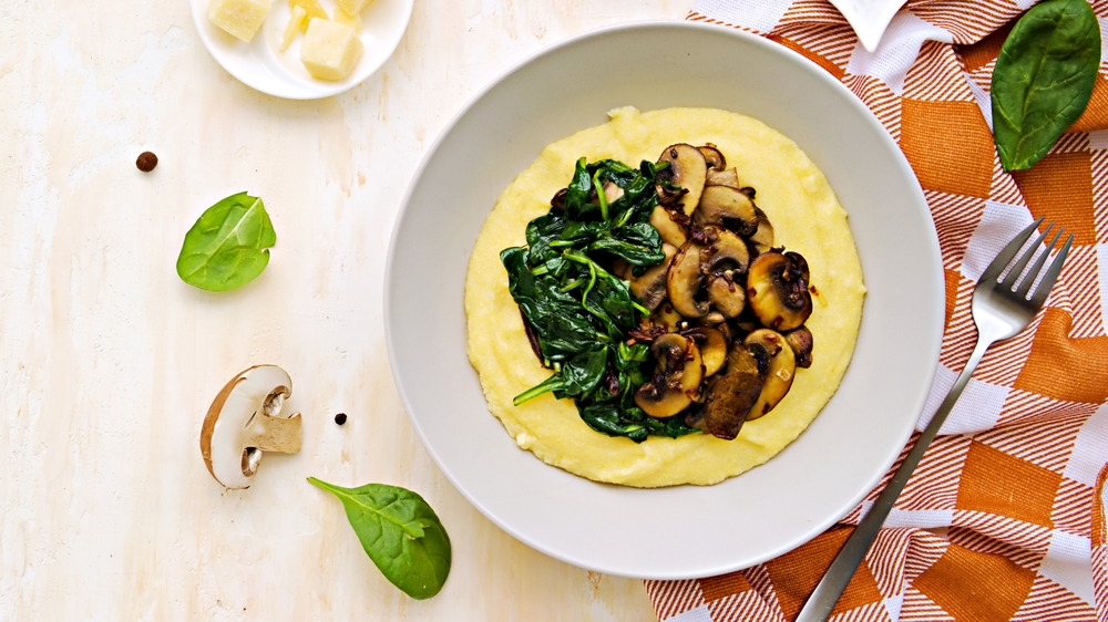 Bowl of grits with mushrooms and sauteed greens