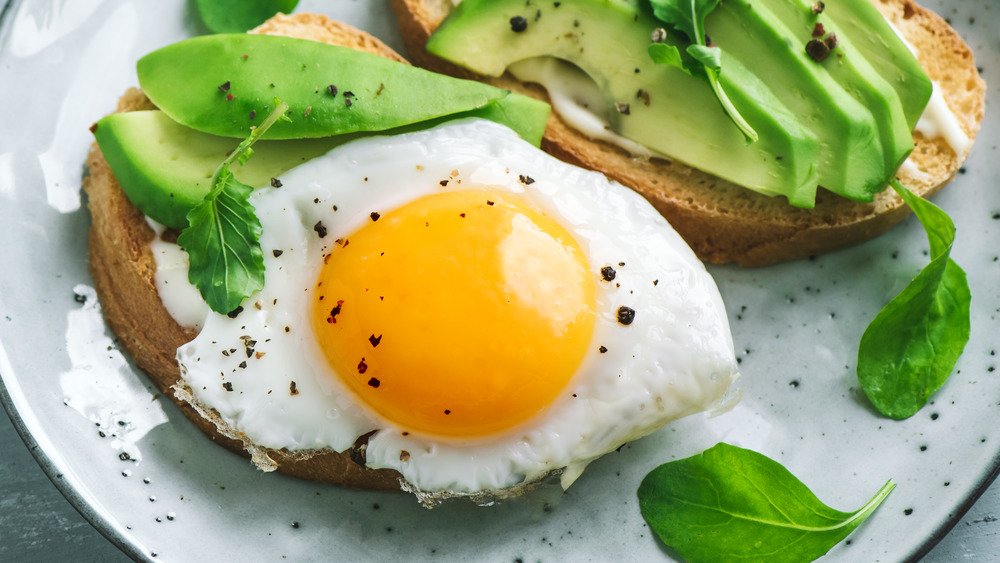 Fried egg with avocado slices and toast