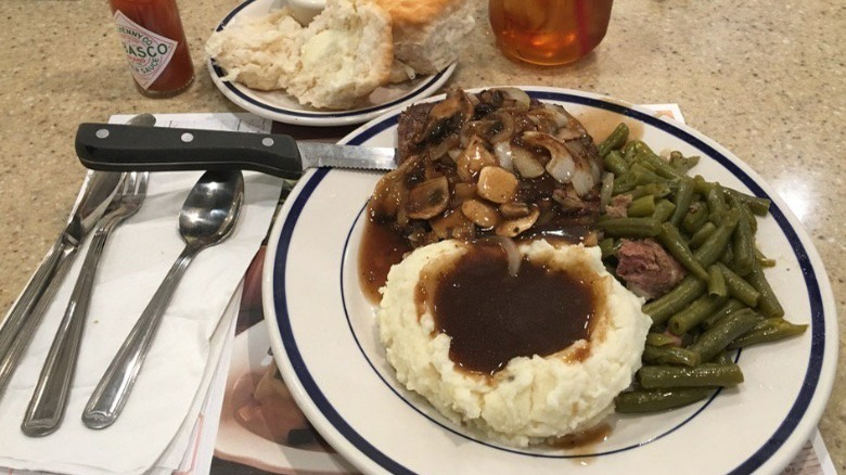 A Bob Evans plate of mashed potatoes, green beans, and steak.