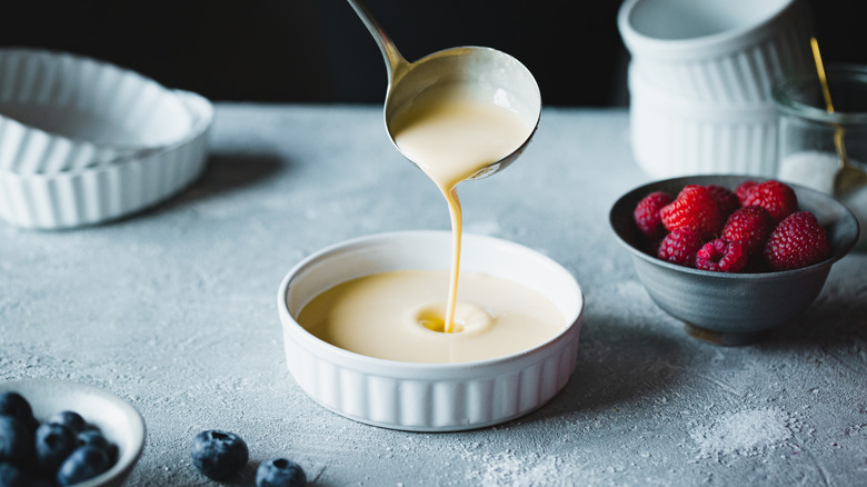 spooning vanilla custard into bowl