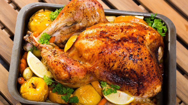 Turkey in a pan with fruits and aromatics